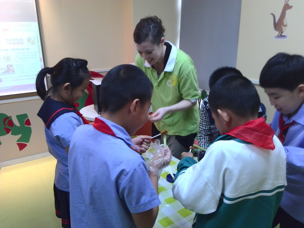 Staff members teach Yongmei students how to make "ants on a log" -- celery topped with peanut butter and raisins.